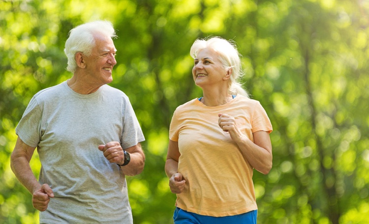 Senior couple running in park